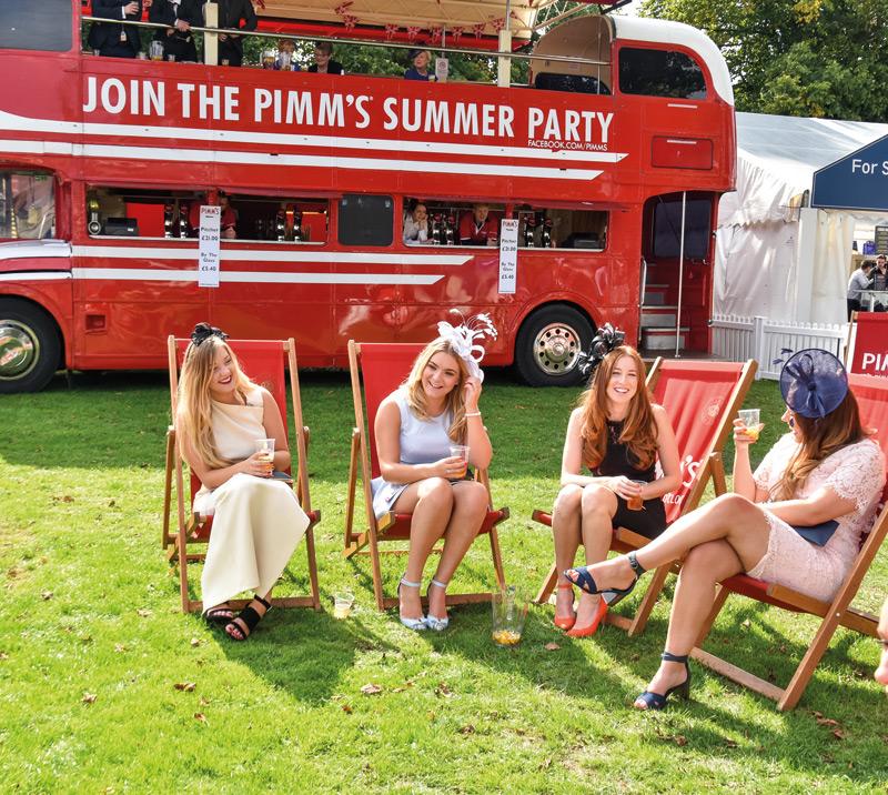 Small group of ladies sitting down drinking.
