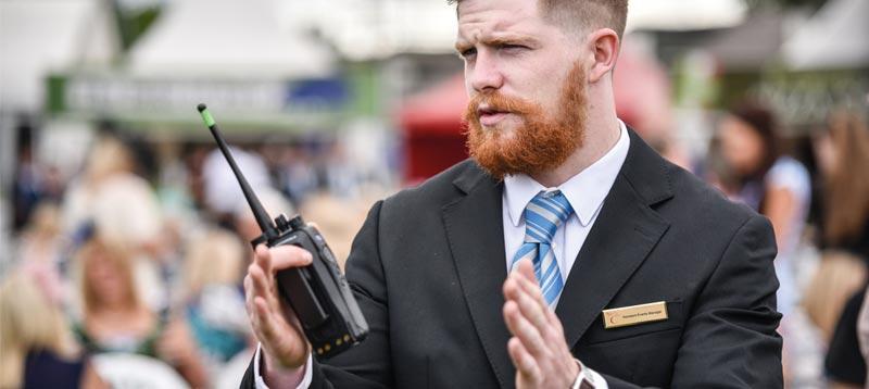 Staff member holding a walkie-talkie.