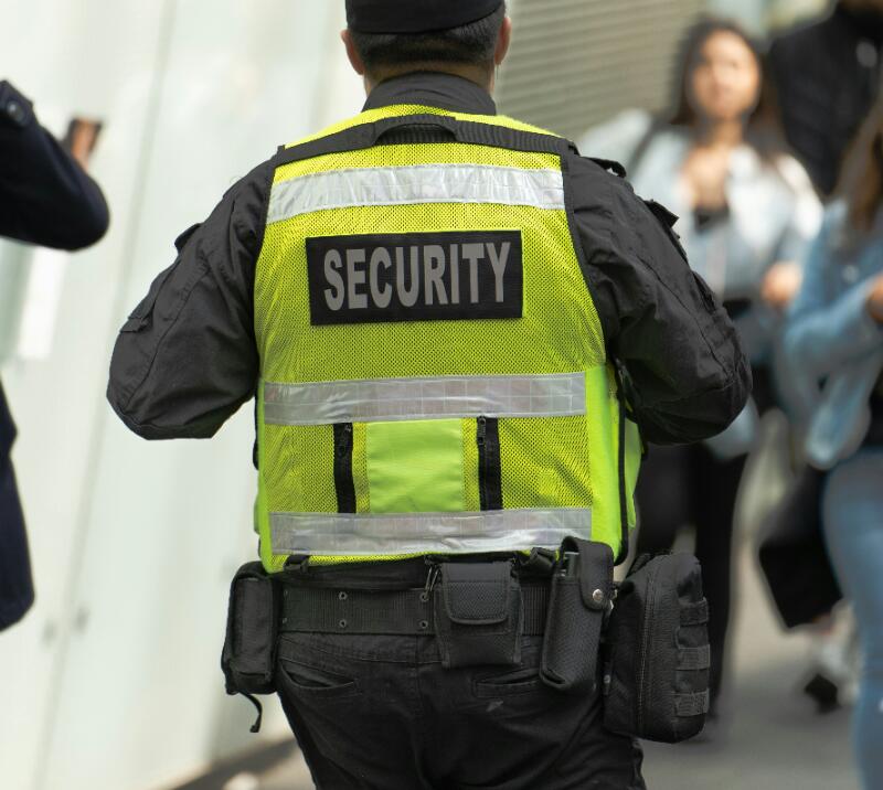 A close up of a security member of staff in their uniform