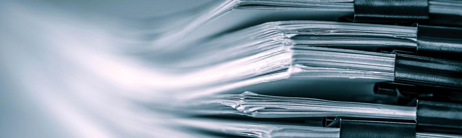 A large collection of documents stored in black holders.