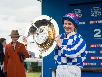 Saffie Osborne holding the St Leger Stakes 2026 trophy
