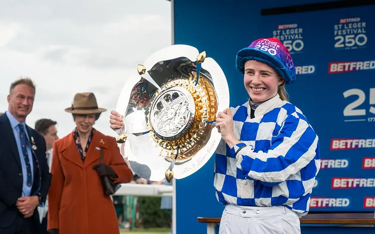 Saffie Osborne holding the St Leger Stakes 2026 trophy