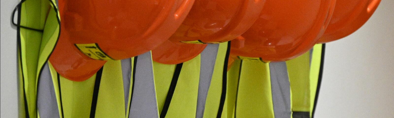 A close up of hi vis vests and hard hats